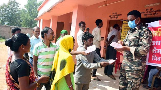 Jharkhand: Voters show their voter ID card to security personnel as they arrive to cast their vote for the by elections in Dumka on Tuesday.(ANI) Jharkhand: Voters show their voter ID card to security personnel as they arrive to cast their vote for the by elections in Dumka on Tuesday.(ANI)