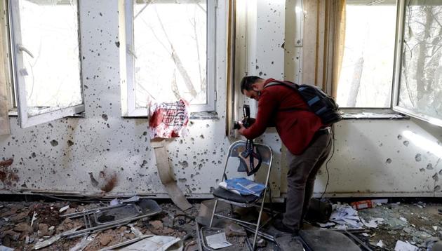 An Afghan journalist films inside a class after yesterday's attack at the university of Kabul, Afghanistan.(REUTERS)