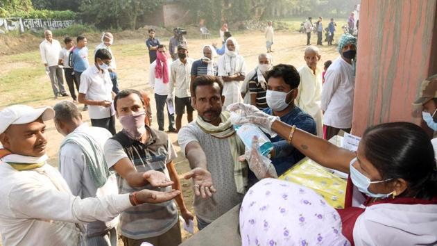 A polling officer dispenses hand sanitizer to voters queuing to cast their ballots during the first phase of Bihar Assembly elections at Naubatpur, in Patna, Bihar, India, on Wednesday, Oct 28, 2020. (Photo by Santosh Kumar/ Hindustan Times) A polling officer dispenses hand sanitizer to voters queuing to cast their ballots during the first phase of Bihar Assembly elections at Naubatpur, in Patna, Bihar, India, on Wednesday, Oct 28, 2020. (Photo by Santosh Kumar/ Hindustan Times)