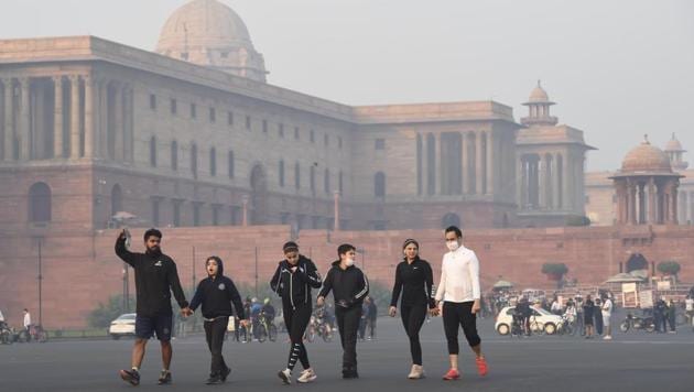 Morning walkers amid smog and cold weather at Vijay Chowk in New Delhi on November 1. Delhi is experiencing a fall in minimum temperature in the range of 3-5 degree Celsius below normal since October 31, which has brought the city closer to its first early November “cold wave” in at least 30 years. (Arvind Yadav / HT Photo)
