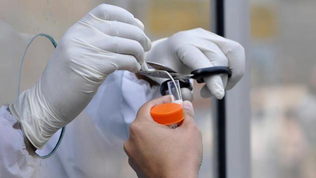 A health worker preserves a swab sample to test for coronavirus at Super Speciality Paediatric Hospital and Post Graduate Teaching Institute in Noida on November 2. The centre aims to implement new awareness campaigns targeted at the 20-40 age bracket as people are now overcome by a sense of “pandemic fatigue” and starting to move outdoors more freely. (Sunil Ghosh / HT Photo) A health worker preserves a swab sample to test for coronavirus at Super Speciality Paediatric Hospital and Post Graduate Teaching Institute in Noida on November 2. The centre aims to implement new awareness campaigns targeted at the 20-40 age bracket as people are now overcome by a sense of “pandemic fatigue” and starting to move outdoors more freely. (Sunil Ghosh / HT Photo)