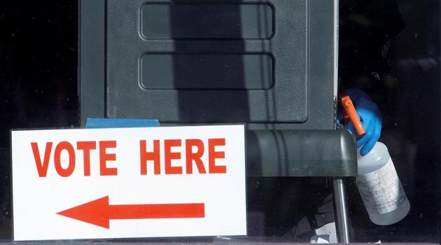 An election worker holds a disinfectant spray bottle as he is seen cleaning a voting booth through the window of a polling station during the 2020 presidential election in Durham, Durham County, North Carolina, U.S., November 3, 2020. REUTERS/Jonathan Drake(Reuters photo) An election worker holds a disinfectant spray bottle as he is seen cleaning a voting booth through the window of a polling station during the 2020 presidential election in Durham, Durham County, North Carolina, U.S., November 3, 2020. REUTERS/Jonathan Drake(Reuters photo)