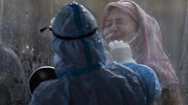 A woman reacts as a health worker takes a nasal swab sample to test for Covid-19 in Srinagar, Kashmir, Wednesday, Nov. 4, 2020.(AP) A woman reacts as a health worker takes a nasal swab sample to test for Covid-19 in Srinagar, Kashmir, Wednesday, Nov. 4, 2020.(AP)
