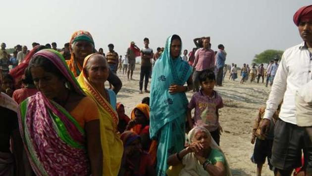 Villagers gather near the bank of the Ganga after a boat capsized in the river in Naugachhia on Thursday.(HT PHOTO)