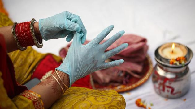 A woman wearing surgical gloves performs Karwa Chauth rituals in New Delhi on November 4. Cases in India have been dipping since hitting a peak of nearly 100,000 a day in September, but experts have sounded alarm over a potential spike due to increased movement during the festive season centred on Diwali. (Sanchit Khanna / HT Photo) A woman wearing surgical gloves performs Karwa Chauth rituals in New Delhi on November 4. Cases in India have been dipping since hitting a peak of nearly 100,000 a day in September, but experts have sounded alarm over a potential spike due to increased movement during the festive season centred on Diwali. (Sanchit Khanna / HT Photo)