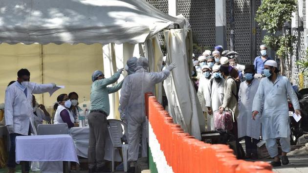 People who took part in a Tablighi Jamaat function earlier in March being checked by a health team before being taken by bus to a quarantine facility amid concerns of infection on March 31, 2020.(Ajay Aggarwal/HT PHOTO)