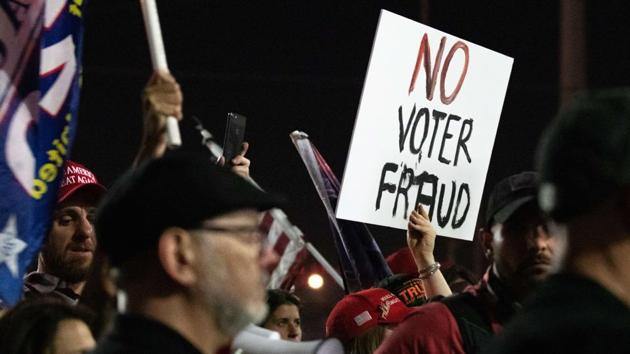 Some of the roughly 200 mostly unmasked protesters, who were faced by a line of armed county sheriffs said they came out after a tweet from Mike Cernovich, a right-wing activist (AFP) Some of the roughly 200 mostly unmasked protesters, who were faced by a line of armed county sheriffs said they came out after a tweet from Mike Cernovich, a right-wing activist (AFP)