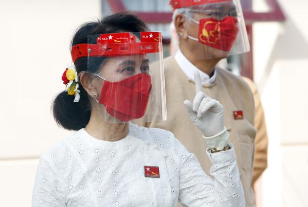 Myanmar leader Aung San Suu Kyi gestures while wearing a face shield, mask and gloves during a flag-raising ceremony to mark the first day of election campaigning at the National League for Democracy party's temporary headquarters in Naypyitaw, Myanmar on Tuesday, September 8, 2020 (AP Photo/Aung Shine Oo) Myanmar leader Aung San Suu Kyi gestures while wearing a face shield, mask and gloves during a flag-raising ceremony to mark the first day of election campaigning at the National League for Democracy party's temporary headquarters in Naypyitaw, Myanmar on Tuesday, September 8, 2020 (AP Photo/Aung Shine Oo)
