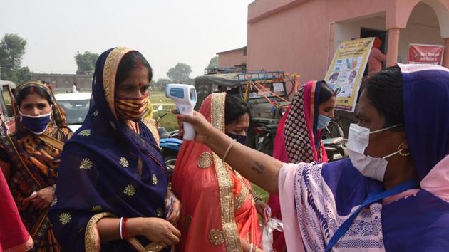 A voter getting their body temperature checked at a polling station before voting in the second phase of Bihar Assembly Elections, at Danapur Diyara, in Patna, Bihar, India, on Tuesday, Nov. 03, 2020 (Photo by Santosh Kumar/ Hindustan Times)