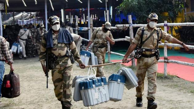 Security personal carrying EVMs and VVPAT machines leave for polling booths from a distribution centre ahead of the third and final phase of Bihar Assembly elections in Hajipur on Friday.(PTI Photo)