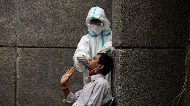 A healthcare worker wearing personal protective equipment (PPE) collects a swab sample from a man amidst the spread of the coronavirus disease (Covid-19), at a testing center in New Delhi, India October 29, 2020.(Reuters photo)