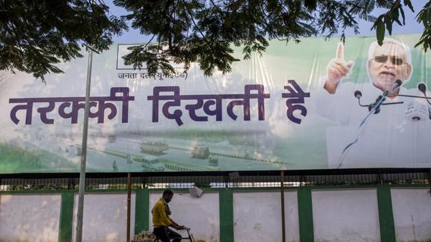 A cyclist rides past a campaign poster for the Janta Dal (United) party featuring current Bihar Chief Minister Nitish Kumar in Patna, Bihar, on Thursday, Oct. 22, 2020.(Bloomberg)