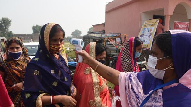 A voter gets her body temperature checked at a polling station before voting in the second phase of Bihar assembly elections in Patna in this file photo.(HT Photo/Santosh Kumar)