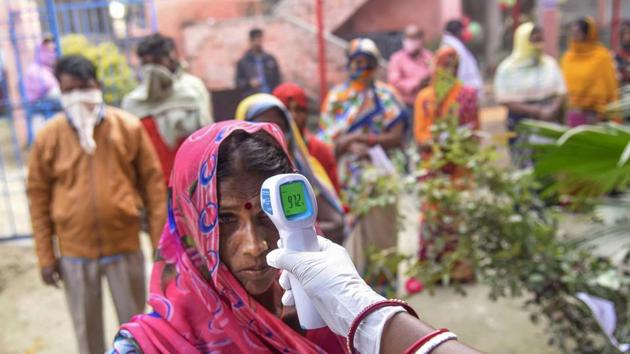 A voter undergoes thermal screening before casting vote during the third phase of Bihar Assembly Elections, at a polling station at Mahua inVaishali on Saturday.(PTI) A voter undergoes thermal screening before casting vote during the third phase of Bihar Assembly Elections, at a polling station at Mahua inVaishali on Saturday.(PTI)