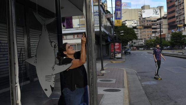 Artist Susan Applewhite attaches her recycled cardboard art onto a bus stop. (AP) Artist Susan Applewhite attaches her recycled cardboard art onto a bus stop. (AP)