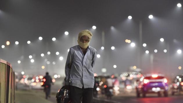A man with his face wrapped in a cloth walks past traffic near Akshardham Temple on National Highway 24 (NH24) on a hazy day, in New Delhi. (Sanjeev Verma /HT PHOTO) A man with his face wrapped in a cloth walks past traffic near Akshardham Temple on National Highway 24 (NH24) on a hazy day, in New Delhi. (Sanjeev Verma /HT PHOTO)