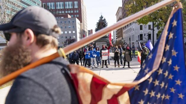 A Trump supporter demonstrating the election results holds an American flag while facing off with counter protesters at the State Capitol in Lansing, Michigan on November 7. Rallies by hundreds of supporters of Republican President Donald Trump, who insisted “this election is far from over,” were more muted in size and scope. (David Goldman / AP) A Trump supporter demonstrating the election results holds an American flag while facing off with counter protesters at the State Capitol in Lansing, Michigan on November 7. Rallies by hundreds of supporters of Republican President Donald Trump, who insisted “this election is far from over,” were more muted in size and scope. (David Goldman / AP)