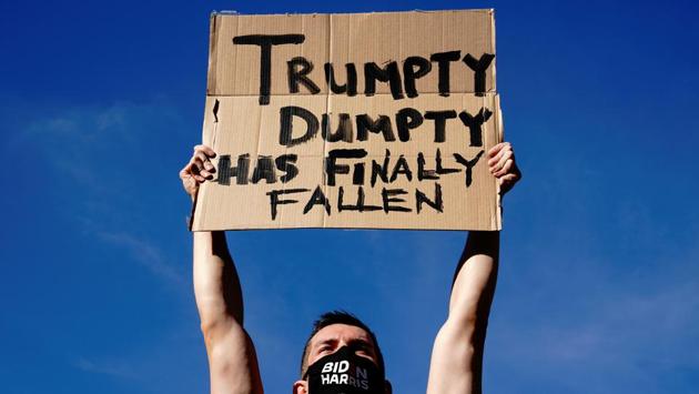 Nick Zajdel holds up a sign at a rally at the Wisconsin State Capitol after media announced that Joe Biden had won the 2020 US presidential election in Madison, on November 7. (Bing Guan / REUTERS) Nick Zajdel holds up a sign at a rally at the Wisconsin State Capitol after media announced that Joe Biden had won the 2020 US presidential election in Madison, on November 7. (Bing Guan / REUTERS)