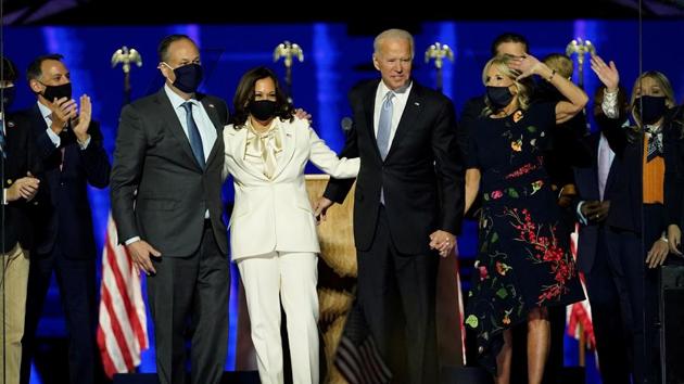 (From L to R) Doug Emhoff, husband of Vice President-elect Kamala Harris, Harris, President-elect Joe Biden and his wife Jill Biden and members of their family salute the crowd on stage after Biden delivered remarks in Wilmington, Delaware, on November 7, 2020.(AFP)