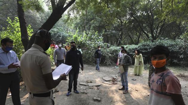 A police volunteer hands out Covid-19 test results in New Delhi on November 6. Meanwhile, Delhi Health Minister Satyendar Jain said while speaking to the media on November 7 that the national capital had hit the peak of its third wave of Covid-19 and the number of cases suggests it has been the worst so far. He added that “cases will come down soon.” (Manish Swarup / AP)
