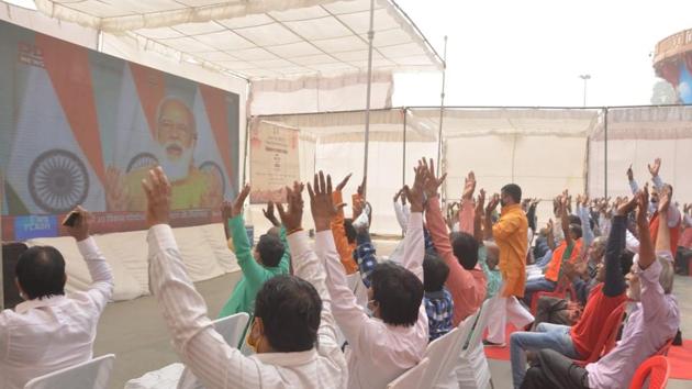 People watching Prime Minister Narendra Modi’s address on a big screen at Dashashwamedh Ghat in Varanasi on Monday(HT PHOTO)