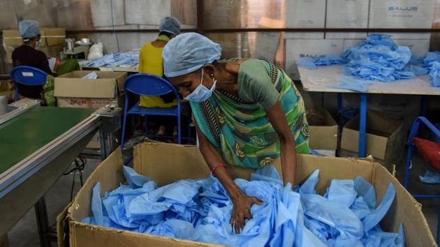 An employee arranges surgical caps at a factory near Changodar, Gujarat on November 8. In Asia, India has the world’s second-highest caseload but has seen a steady slowdown since September, despite the start of the Hindu festival season. Total cases have exceeded 8.5 million cases in India the daily average is 46,200, according to Reuters data. (Sam Panthaky / AFP)