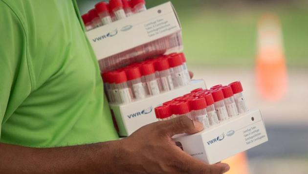 A healthcare worker carries specimen collection tubes at a coronavirus disease (Covid-19) drive-in testing location in Houston, Texas, US, August 18, 2020. REUTERS/Adrees Latif/File Photo