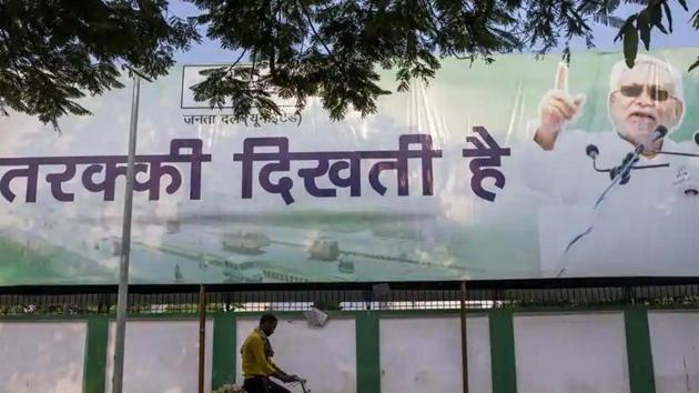 A cyclist rides past a campaign poster for the Janta Dal (United) party featuring current Bihar Chief Minister Nitish Kumar in Patna, Bihar.(Bloomberg) A cyclist rides past a campaign poster for the Janta Dal (United) party featuring current Bihar Chief Minister Nitish Kumar in Patna, Bihar.(Bloomberg)