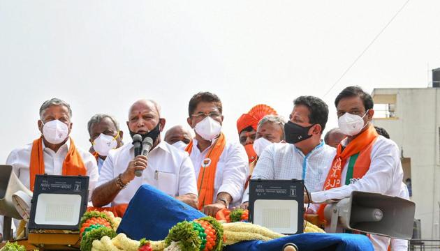 Karnataka Chief minister BS Yediyurappa during an election campaign in support of BJP candidate from Rajrajeshwari Nagar constituency Munirathna Naidu (R), at Srinivas Nagar in Bengaluru.(PTI)