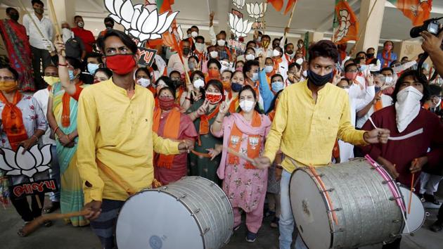 Supporters of the Bharatiya Janata Party (BJP) hold their party symbol and flags as they gather to celebrate NDA’s lead in Bihar assembly elections. (PTI Photo)