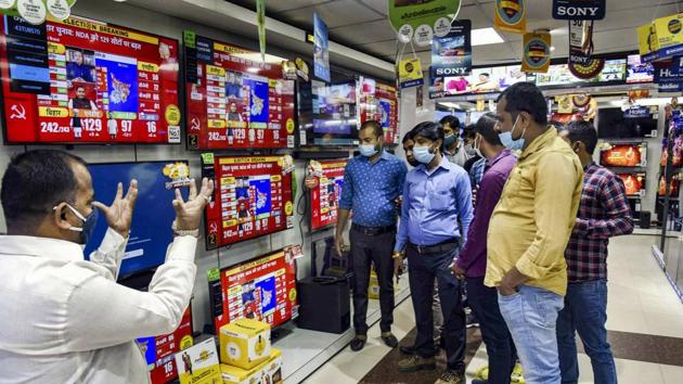 Locals watch the election coverage on the counting day of Bihar assembly polls, in Patna on Tuesday. (PTI) Locals watch the election coverage on the counting day of Bihar assembly polls, in Patna on Tuesday. (PTI)