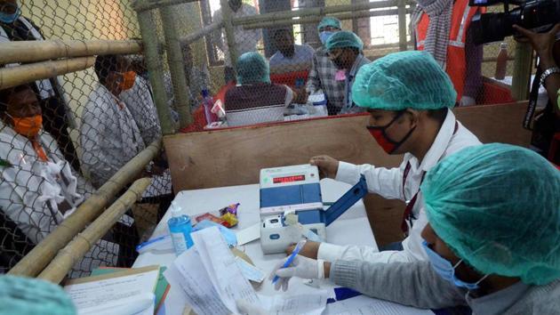 Election officials wearing masks carry out counting of votes at a centre in Patna on Tuesday.(ANI Photo)