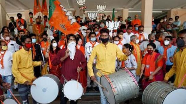 Supporters of India's ruling Bharatiya Janata Party (BJP) hold their party symbol and flags as they gather to celebrate after learning of the initial poll results of the Bihar state assembly election and by-elections in Gujarat, Karnataka and Madhya Pradesh states, in Gandhinagar, India, November 10, 2020. (Reuters)