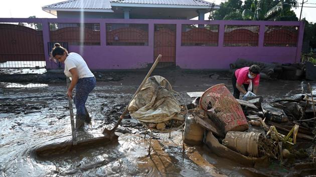 A woman tries to clear mud from the front of her house in Planeta, in the Honduran department of Cortes, on November 9 after the passage of Hurricane Eta, now downgraded to Tropical Storm. At least 200 people are dead or missing after Eta ripped through Nicaragua, Guatemala, and Honduras, causing flooding and landslides, AFP reported. (Orlando Sierra / AFP)