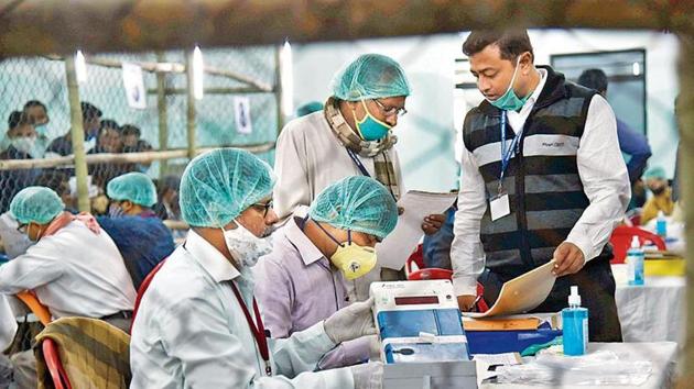 Election officers wearing face masks count votes for the Bihar assembly polls, at a counting centre in Patna on Tuesday. (AP Photo) Election officers wearing face masks count votes for the Bihar assembly polls, at a counting centre in Patna on Tuesday. (AP Photo)