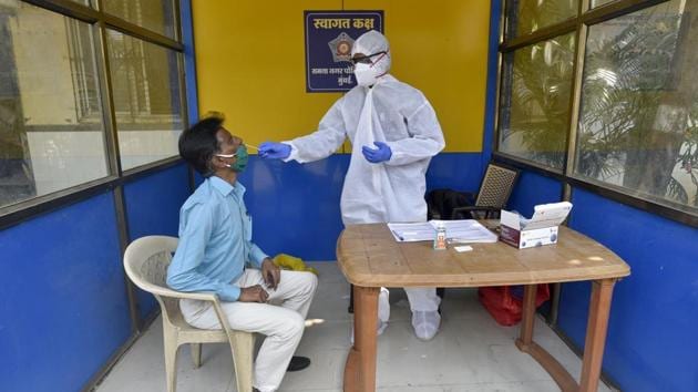 Healthcare workers during a Covid-19 screening and swab test at Samta Nagar police station,Kandivali (E) in Mumbai .(Satyabrata Tripathy/HT Photo)