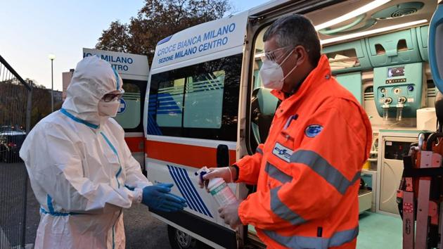 A worker of the Italian Voluntary Association of First Aid and Public Assistance, Croce Bianca, dispenses hand sanitizer to his colleague after transporting a Covid-19 patient in Milan, Italy on November 9. In Italy, daily average new cases are surging at more than 32,500. Deaths have been rising by more than 320 per day over the past three weeks, Reuters reported. (Miguel Medina / AFP) A worker of the Italian Voluntary Association of First Aid and Public Assistance, Croce Bianca, dispenses hand sanitizer to his colleague after transporting a Covid-19 patient in Milan, Italy on November 9. In Italy, daily average new cases are surging at more than 32,500. Deaths have been rising by more than 320 per day over the past three weeks, Reuters reported. (Miguel Medina / AFP)