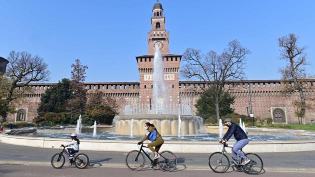 A family wearing face masks cycle in front of the Sforzesco Castle in Milan, Italy on November 7. Over the past week, Europe has seen 280,000 cases a day, up 10 per cent from the week earlier, representing just over half of all new infections recorded globally, Reuters reported. (Miguel Medina / AFP) A family wearing face masks cycle in front of the Sforzesco Castle in Milan, Italy on November 7. Over the past week, Europe has seen 280,000 cases a day, up 10 per cent from the week earlier, representing just over half of all new infections recorded globally, Reuters reported. (Miguel Medina / AFP)
