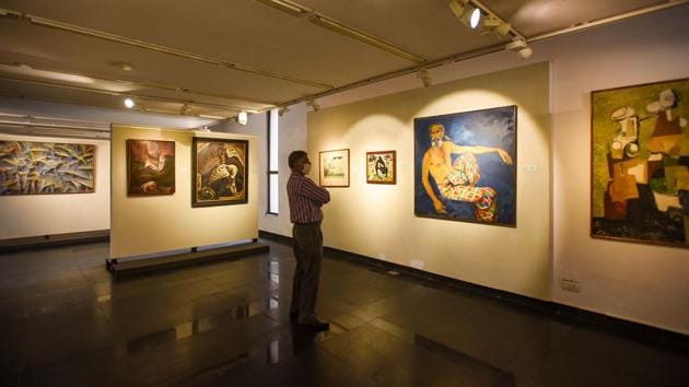 A visitor looks at the paintings on display at National Gallery of Modern Art in New Delhi on November 10. The standard operating procedures (SoPs) in place have for now barred use of audio guides by venues unless they can be disinfected after every use. (Amal KS / HT Photo)