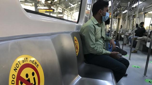 Commuters wearing face masks as a precautionary measure against the coronavirus and travel in a metro train which has markings to ensure social distancing in New Delhi. (AP) Commuters wearing face masks as a precautionary measure against the coronavirus and travel in a metro train which has markings to ensure social distancing in New Delhi. (AP)