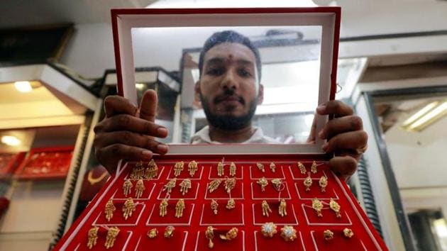 A vendor shows gold stud earrings at a jewellery showroom in Sri Lanka.(Reuters File Photo)