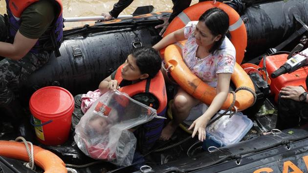 A rescuer covers a baby with a plastic sheet as they ride a rubber boat while floods continue to rise in Marikina, Philippines due to Typhoon Vamco on November 12. The typhoon swelled rivers and flooded low-lying areas as it passed over the storm-battered northeast Philippines, where rescuers were deployed early November 12 to help people flee the rising waters. (Aaron Favila / AP) A rescuer covers a baby with a plastic sheet as they ride a rubber boat while floods continue to rise in Marikina, Philippines due to Typhoon Vamco on November 12. The typhoon swelled rivers and flooded low-lying areas as it passed over the storm-battered northeast Philippines, where rescuers were deployed early November 12 to help people flee the rising waters. (Aaron Favila / AP)