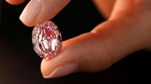 A model poses with "The Spirit of the Rose", the world's largest vivid purple-pink diamond with 14.83-carat.(REUTERS)