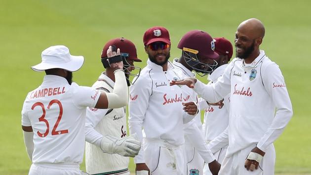 West Indies' Roston Chase celebrates taking the wicket of England's Rory Burns, caught by West Indies' Rakheem Cornwall with teammates.(REUTERS) West Indies' Roston Chase celebrates taking the wicket of England's Rory Burns, caught by West Indies' Rakheem Cornwall with teammates.(REUTERS)