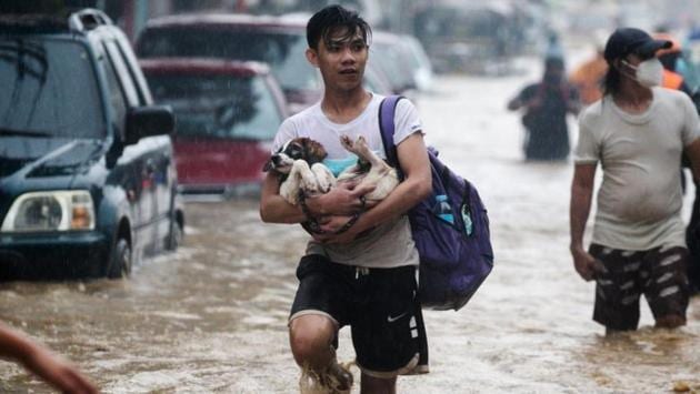 A man carries a dog, while evacuating from a flooded community in Marikina, Metro Manila, Philippines, on November 12. Typhoon Vamco struck areas still reeling from Goni, the most powerful typhoon in the world this year, which killed 25 people and destroyed thousands of homes earlier this month. (Eloisa Opez / REUTERS) A man carries a dog, while evacuating from a flooded community in Marikina, Metro Manila, Philippines, on November 12. Typhoon Vamco struck areas still reeling from Goni, the most powerful typhoon in the world this year, which killed 25 people and destroyed thousands of homes earlier this month. (Eloisa Opez / REUTERS)