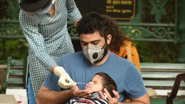 A health worker collects a swab sample from a child to test for coronavirus infection at Chhatrapati Shivaji Park in Shivaji Nagar, Gurugram on Thursday.(Parveen Kumar/HT Photo)