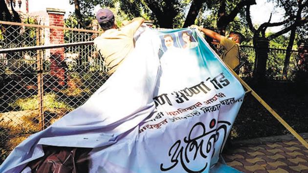Police officials remove a flex put up by a political party near Council hall on Thursday. Candidates visited the office to file their nomination papers.(Rahul Raut/HT PHOTO) Police officials remove a flex put up by a political party near Council hall on Thursday. Candidates visited the office to file their nomination papers.(Rahul Raut/HT PHOTO)