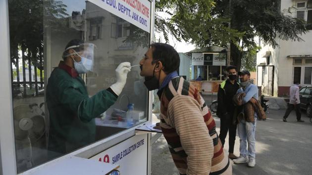 A health worker collects a nasal swab sample to test for Covid-19 at a government hospital in Jammu . (AP) A health worker collects a nasal swab sample to test for Covid-19 at a government hospital in Jammu . (AP)