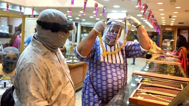 Citizens take precautions as they buy gold on the occasion of Dhanteras on Friday. (Satish Bate/HT Photo) Citizens take precautions as they buy gold on the occasion of Dhanteras on Friday. (Satish Bate/HT Photo)