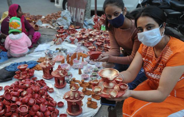Young girls shopping for diyas at the Sector 19 market.(Keshav Singh/HT)